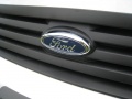 2010 Ford Transit Connect. the grille logo hides the hood release.